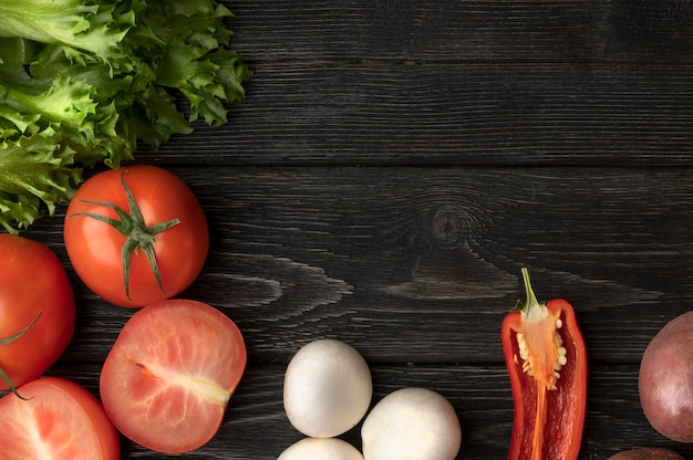 Légumes sur une table en bois noire. Vue de dessus avec espace copie