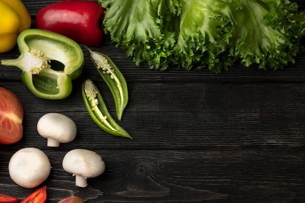 Légumes sur une table en bois noire. Vue de dessus avec espace copie