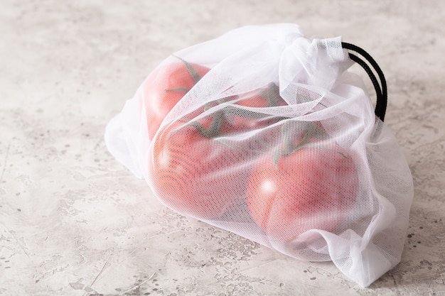 Légumes tomates dans un sac en nylon à mailles réutilisable, concept zéro déchet sans plastique