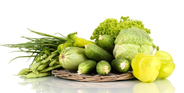 Légumes verts frais sur tapis en osier isolé sur blanc