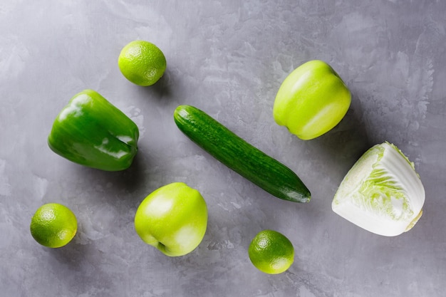 Légumes verts et fruits sur fond gris. Concept de nourriture végétarienne saine. Vue de dessus