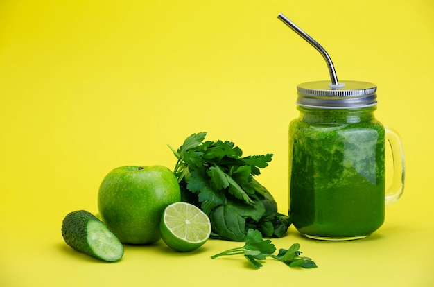 Légumes verts et fruits sur fond jaune vif Recette de smoothie avec une sélection