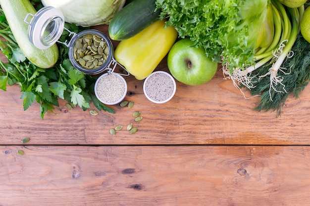 Légumes verts hypoallergéniques dans une boîte en bois et les graines. La nourriture végétarienne. Mise au point sélective, vue de dessus.