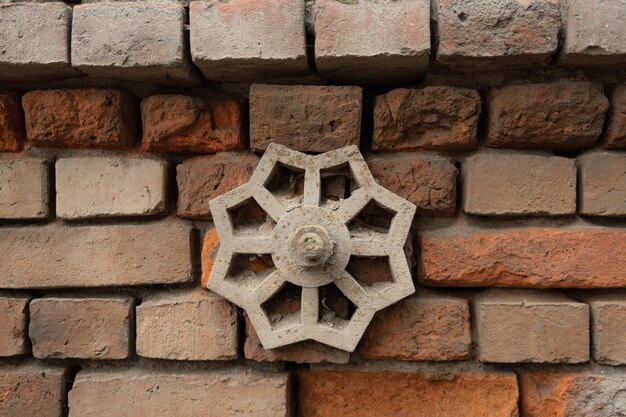 Élément métallique sur un vieux mur de briques