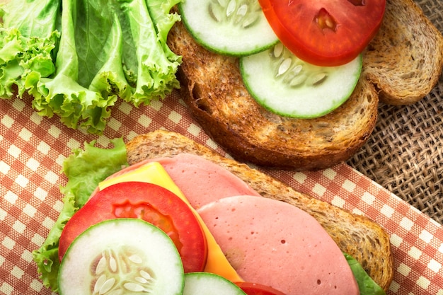 Élément de sandwiches grillés pain avec bacon, jambon et fromage avec légumes, en bonne santé