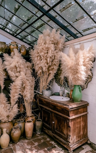 Éléments de décor intérieur Fleurs séchées et cruches en argile dans une salle de bain rustique