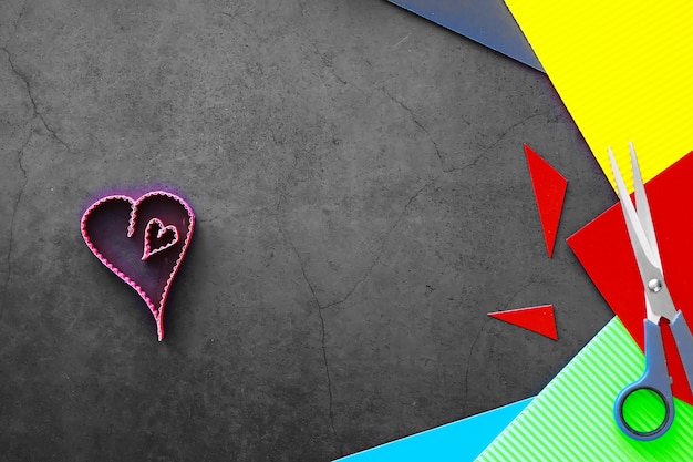 Éléments en papier en forme de coeur sur fond de pierre sombre. Concept de l'amour et de la Saint-Valentin. Conception de carte de voeux d'anniversaire.