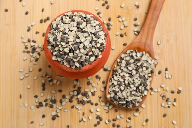 Photo lentille noire fendue également connue sous le nom de black gram, black urad dal, vigna mungo, urad bean sur fond de bois.