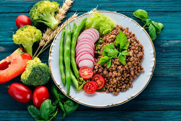 Lentilles aux radis tomates cerises haricots et légumes Alimentation saine Sur une table en bois bleue Vue de dessus Espace libre pour le texte