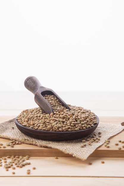 Lentilles crues sur plaque en bois et cuillère