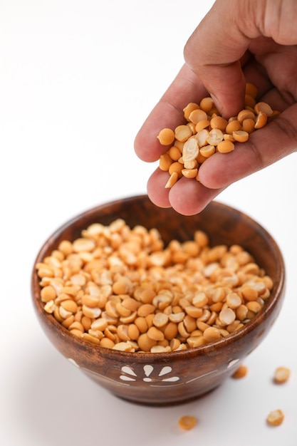 Lentilles de pois chiches séchées dans un bol en bois sur fond blanc, Split Chickpea également connu sous le nom de Chana Dal