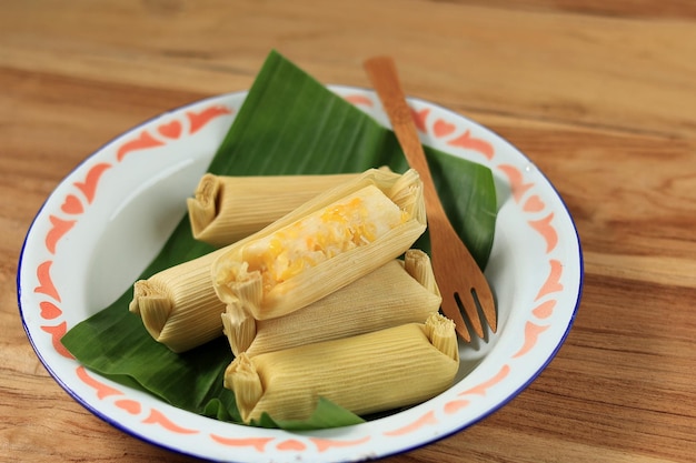 Photo lepet jagung farine de maïs cuite à la vapeur et noix de coco râpée enveloppée de feuilles de maïs