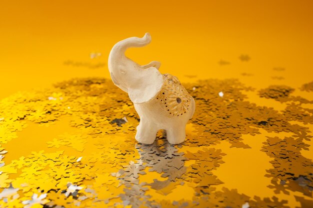 Éléphant blanc, jouet de Noël se tient sur des étincelles et un fond jaune