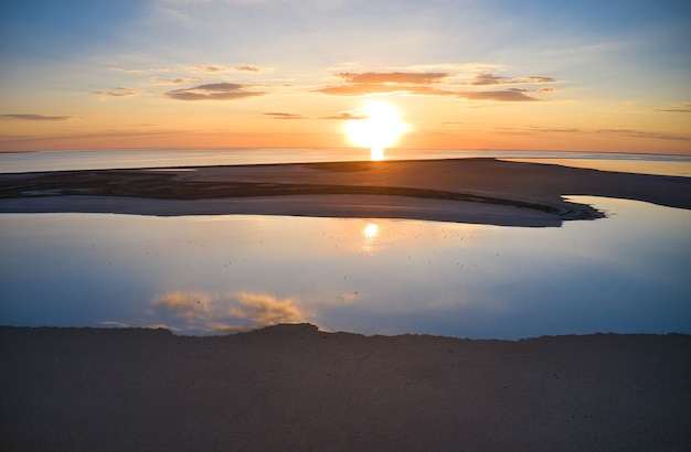 Îles insolites sur un lac brillant et coucher de soleil coloré