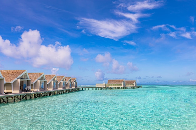 Îles Maldives au-dessus de villas sur pilotis, bungalow, jetée en bois et fantastique lagon marin. Voyage exotique