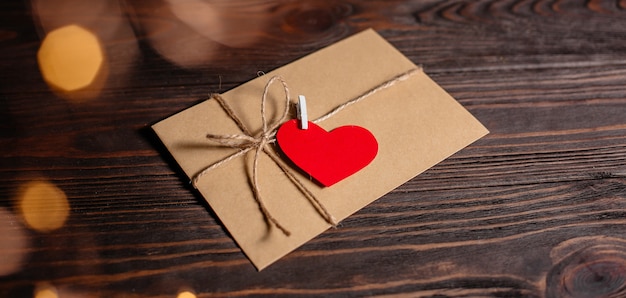 Lettre d'amour avec un coeur sur fond de lumières, d'amour et de concept de la Saint-Valentin sur une table en bois