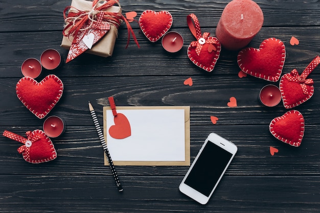 Une lettre d&#39;amour, coeurs décoratifs, cadeaux et smartphone sur une table sombre pour la Saint-Valentin