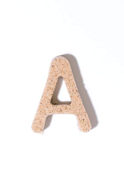 Photo lettre a du sable isolé dans l'alphabet de concept d'été blanc