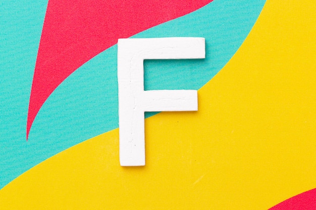 Lettre F de l'alphabet sur la vue de dessus de fond coloré