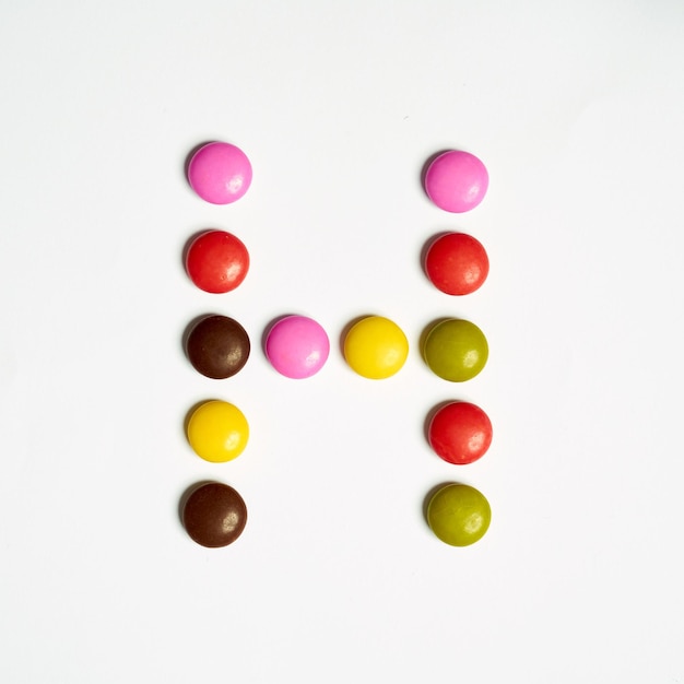 Lettre H de bonbons colorés sucrés, alphabet isolé sur fond blanc. H