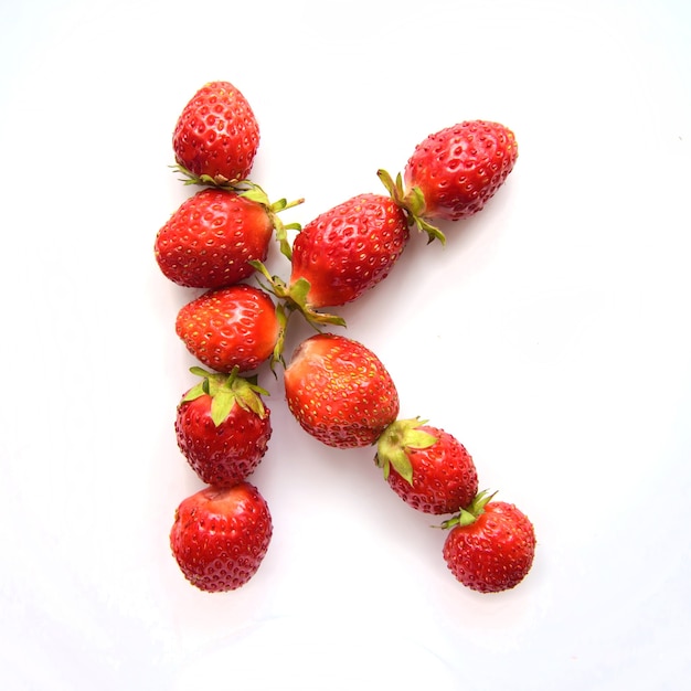 Lettre K de l'alphabet anglais de fraises fraîches rouges sur fond blanc