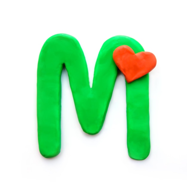 Lettre de pâte à modeler verte M alphabet anglais avec coeur rouge qui signifie amour