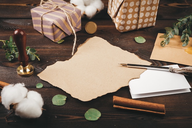 Lettre vide avec une plume sur le vieux fond en bois orné d'objets de Noël