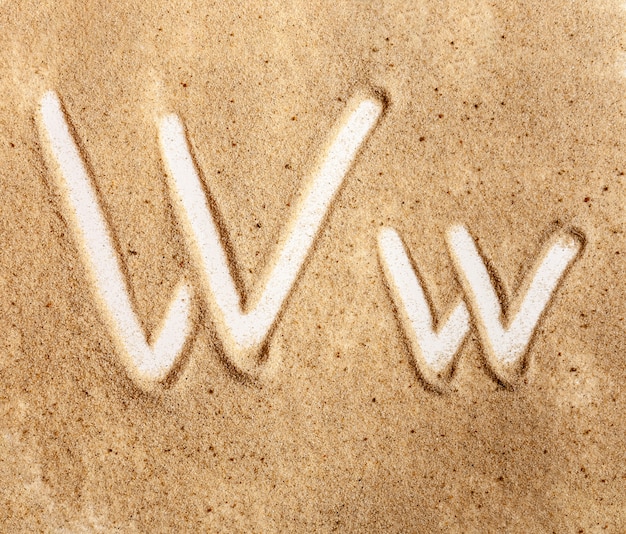 Lettre W alphabet manuscrit anglais dans le sable