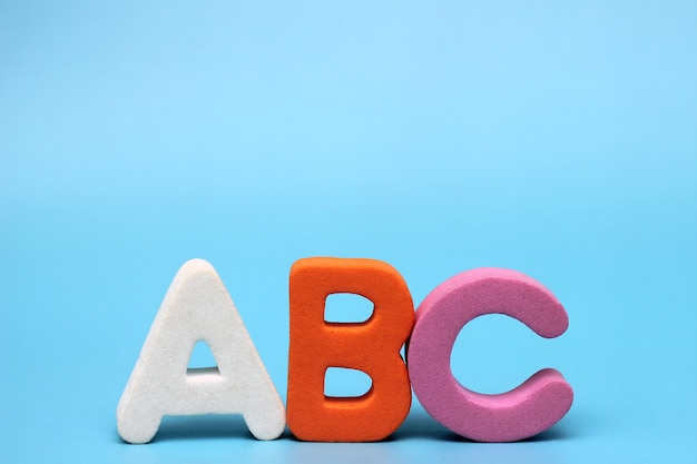 Les lettres ABC sont isolées sur un fond bleu. Apprendre une langue étrangère.