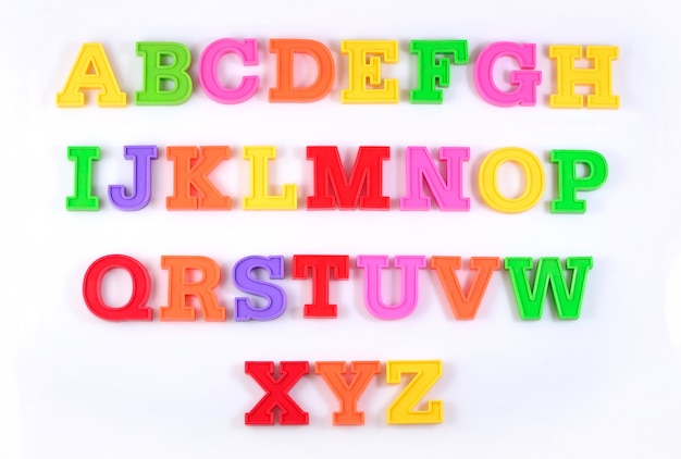 Lettres de l'alphabet en plastique coloré sur fond blanc