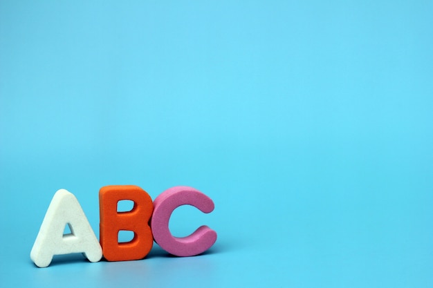 Les lettres de couleur de l'ABC sont isolées sur un fond bleu