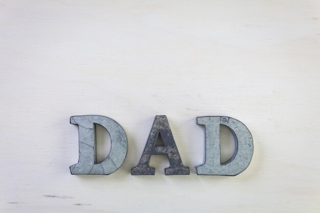 Lettres en métal DAD sur fond de bois peint.