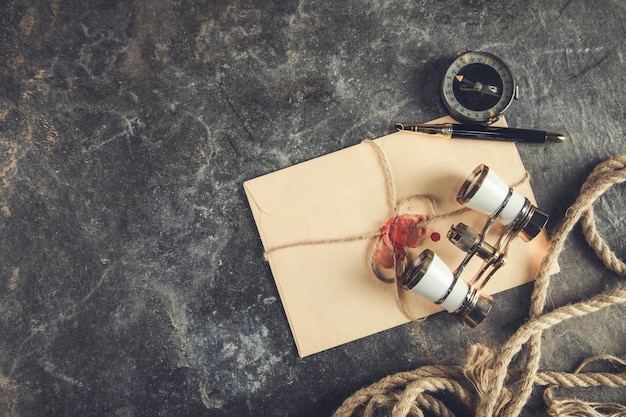 Lettres vintage avec boussole et jumelles sur table