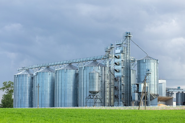 Élévateur de grenier moderne et ligne de nettoyage de semences. Silos d'argent sur l'usine de transformation et de fabrication pour le stockage et le nettoyage à sec de produits agricoles, de farine, de céréales et de céréales.