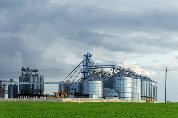 Élévateur de grenier moderne et ligne de nettoyage de semences. Silos d'argent sur l'usine de transformation et de fabrication pour le stockage et le nettoyage à sec de produits agricoles, de farine, de céréales et de céréales.