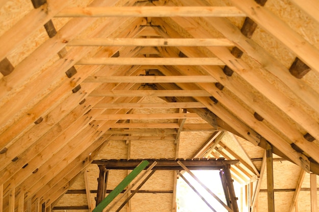 Élévation de la ferme de toit au deuxième étage d'une nouvelle construction résidentielle Vue intérieure d'une structure de toit en bois Préparation du toit d'OSB