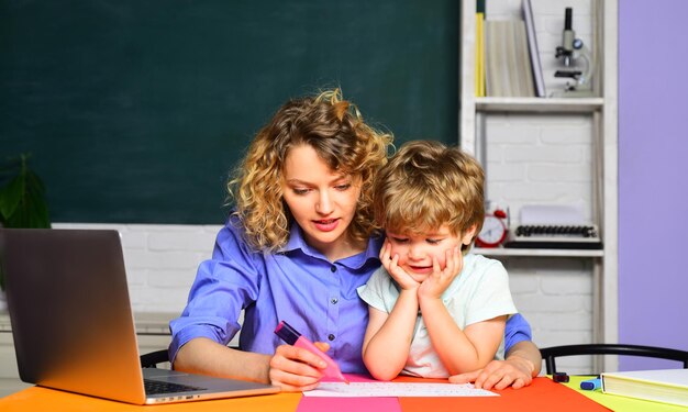 Élève du primaire de l'école petit enfant dans les enseignants de première année élève du jour apprenant des lettres et