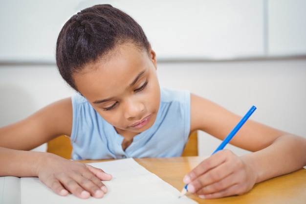 Élève écrit dans un cahier