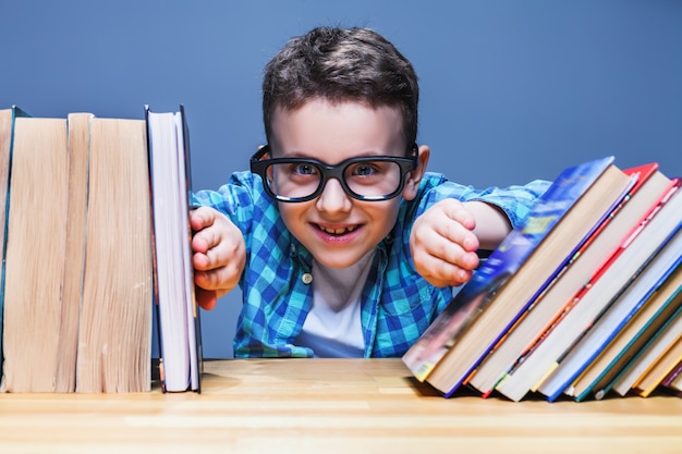 Élève heureux dans des verres contre des livres