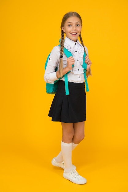 Élève avec de longues tresses allant à l'école. Totalement prêt. La vie quotidienne des écolières. Club de l'école. Enseignement privé. Teen avec sac à dos. Écolière souriante mignonne. Fille petite écolière porter sac à dos.