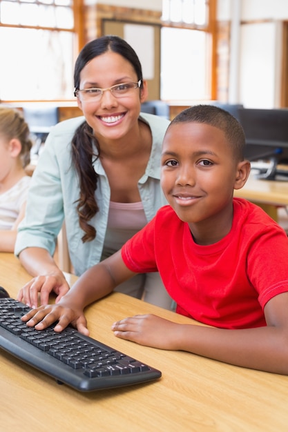 Élève mignon en classe d&#39;informatique avec professeur