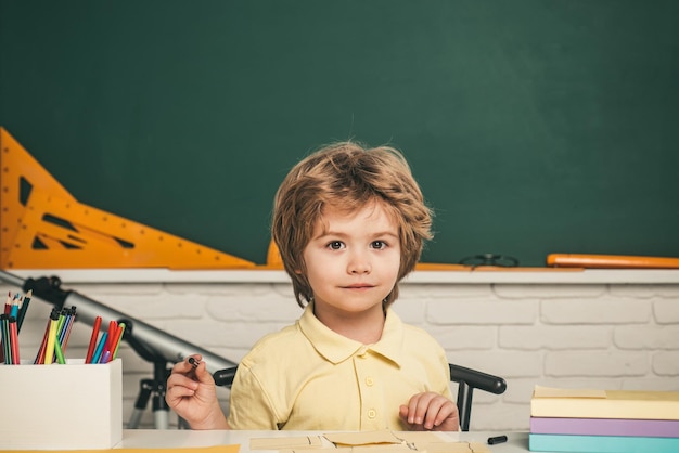 Élève mignon avec drôle de visage scolarisation travail portrait d'élève de l'école primaire étudier à l'intérieur