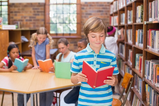 Élève mignon à la recherche de livres dans la bibliothèque