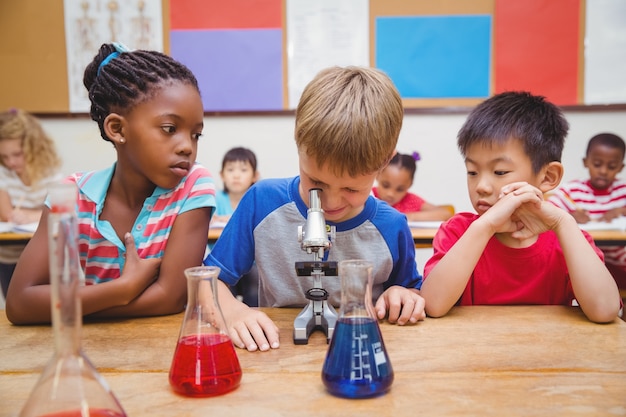 Élève mignon regardant à travers le microscope