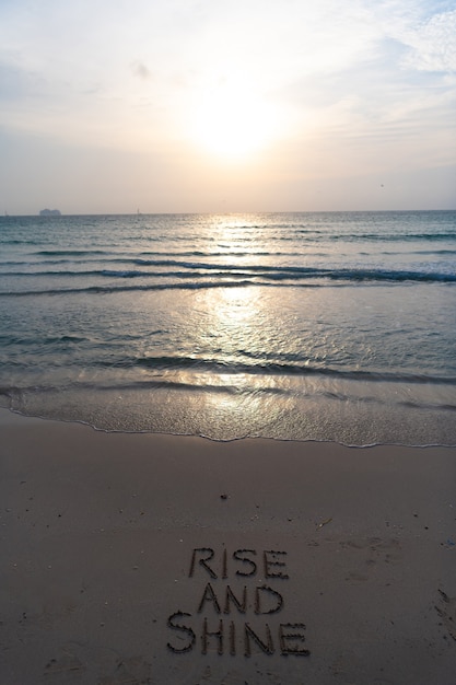 Lever et briller. Tôt le matin, lever de soleil sur la mer. Coucher de soleil sur l'océan sur l'eau de mer avec ciel coucher de soleil. mots sur le sable de la plage. Lever de soleil doré de paysage marin sur la mer. Belle notion de nature. Plage de Miami.