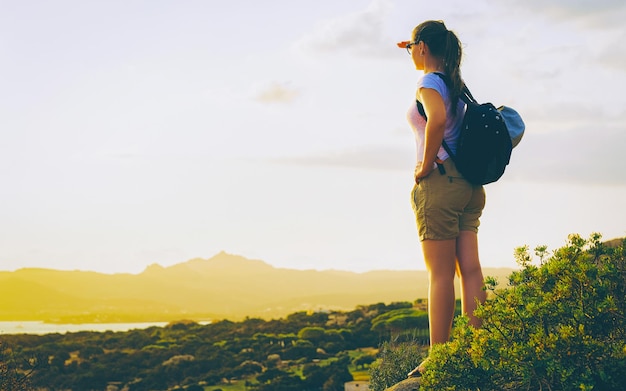 Lever ou coucher du soleil et jeune fille à Baja Sardinia de Costa Smeralda en mer Méditerranée sur l'île de Sardaigne en Italie. Femme et Sardaigne en été.