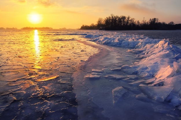 Photo lever du soleil et mer gelée. beau paysage d'hiver avec lac le matin.