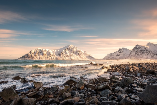 Lever du soleil sur la montagne de neige au littoral à la plage de Skagsanden