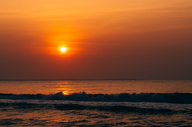 lever du soleil orange contre la mer avec des vagues