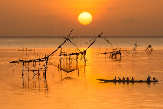 Lever du soleil avec pêcheur sur bateau